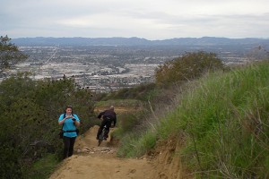 A mountain biker speeds past a pedestrian on the trail. Mountain biking is illegal in Los Angeles city parks, but permitted in county parks.